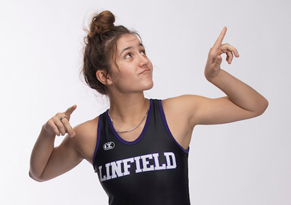 Hanna Gillas '26 posing with her arms flexed in her ѨƵ wrestling singlet